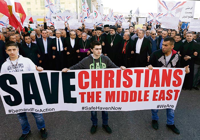 Assyrians hold banners as they march in solidarity with the Assyrians abducted by Islamic State fighters in Syria earlier this week, in Beirut